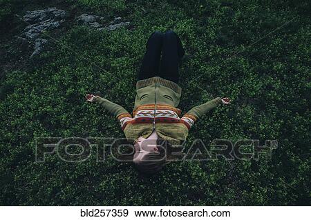 Caucasian woman laying in grass View Large Photo Image Stock Photo - Caucasian woman laying in grass. Fotosearch