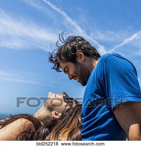 Stock Photo - Caucasian woman laying in lap of man. Fotosearch