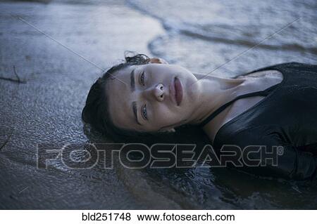 Caucasian woman laying on beach in waves View Large Photo Image Stock Photo - Caucasian woman laying on beach in waves. Fotosearch