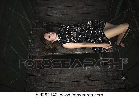 Caucasian woman laying on wooden bridge View Large Photo Image Stock Image - Caucasian woman laying on wooden bridge. Fotosearch