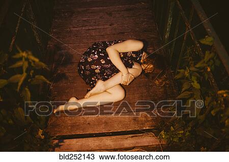 Caucasian woman laying on wooden bridge View Large Photo Image Stock Image - Caucasian woman laying on wooden bridge. Fotosearch