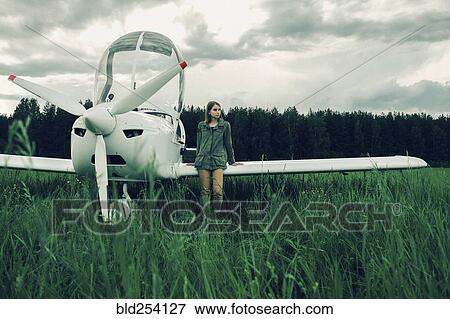 Caucasian woman leaning on airplane wing View Large Photo Image Stock Photo - Caucasian woman leaning on airplane wing. Fotosearch