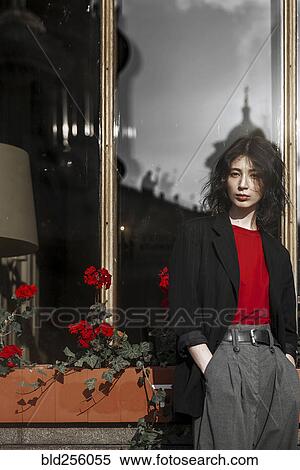 Stock Photography - Caucasian woman leaning on flower box near window. Fotosearch