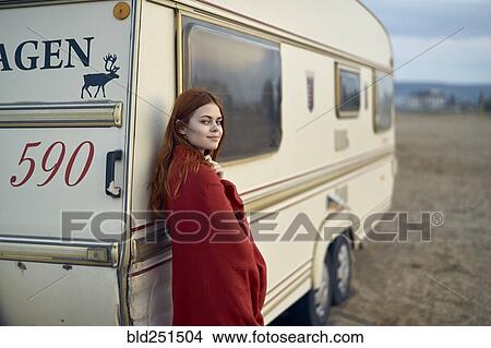 Picture - Caucasian woman leaning on motor home. Fotosearch