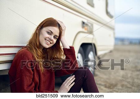 Stock Photo - Caucasian woman leaning on motor home. Fotosearch