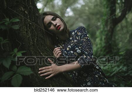 Caucasian woman leaning on tree trunk View Large Photo Image Stock Photograph - Caucasian woman leaning on tree trunk. Fotosearch