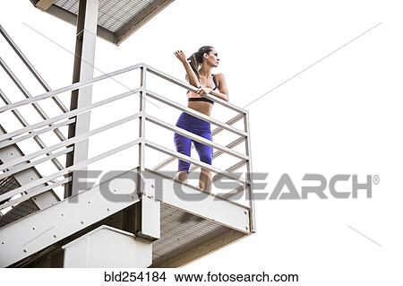 Picture - Caucasian woman leaning on urban staircase. Fotosearch