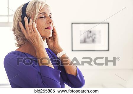 Caucasian woman listening to headphones View Large Photo Image Stock Photography - Caucasian woman listening to headphones. Fotosearch