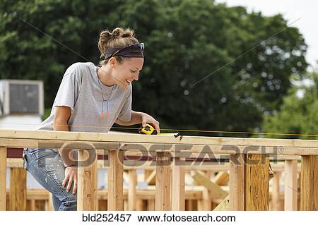 Caucasian woman measuring at construction site View Large Photo Image Stock Photo - Caucasian woman measuring at construction site. Fotosearch