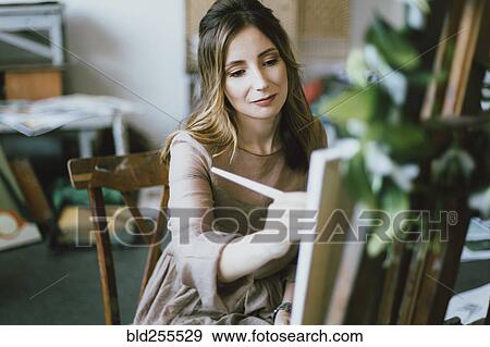 Stock Photo - Caucasian woman painting on canvas. Fotosearch