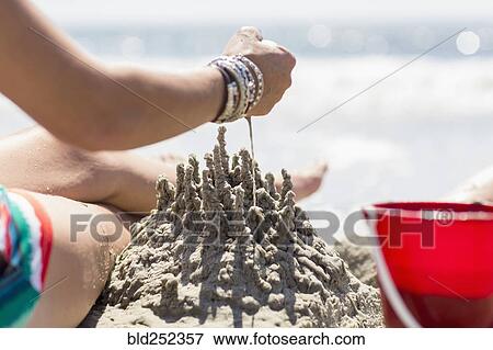 Caucasian woman playing with sand castle at beach View Large Photo Image Stock Photo - Caucasian woman playing with sand castle at beach. Fotosearch
