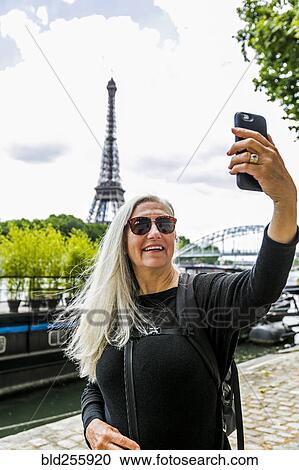 Caucasian woman posing for cell phone selfie near Eiffel Tower View Large Photo Image Stock Image - Caucasian woman posing for cell phone selfie near Eiffel Tower. Fotosearch