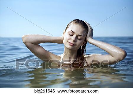 Stock Photograph - Caucasian woman relaxing in ocean. Fotosearch