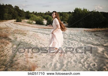 Stock Image - Caucasian woman running on beach. Fotosearch
