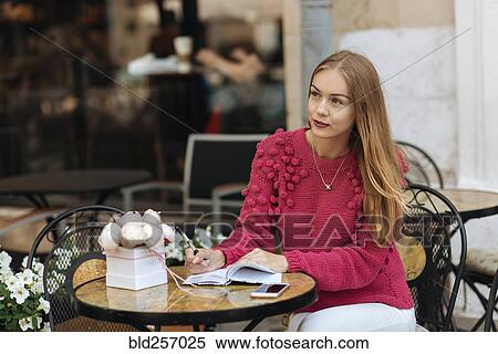 Caucasian woman sitting at table writing in journal View Large Photo Image Stock Photography - Caucasian woman sitting at table writing in journal. Fotosearch