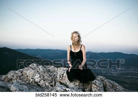 Caucasian woman sitting on rock near mountains View Large Photo Image Stock Photography - Caucasian woman sitting on rock near mountains. Fotosearch