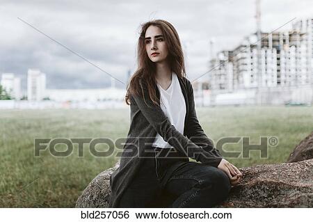 Caucasian woman sitting on rock View Large Photo Image Stock Photograph - Caucasian woman sitting on rock. Fotosearch
