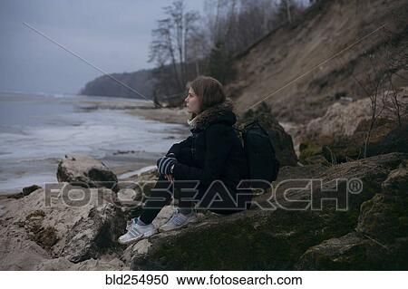 Caucasian woman sitting on rocks near ocean View Large Photo Image Stock Image - Caucasian woman sitting on rocks near ocean. Fotosearch