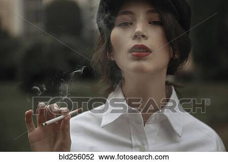 Stock Image - Caucasian woman smoking cigarette. Fotosearch