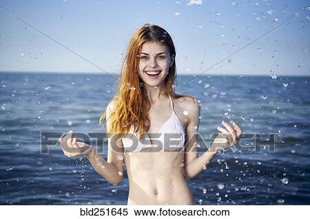 Stock Photography - Caucasian woman splashing in ocean. Fotosearch