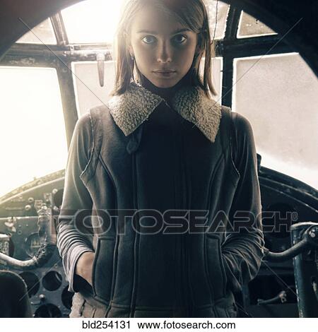 Stock Image - Caucasian woman standing in cockpit. Fotosearch