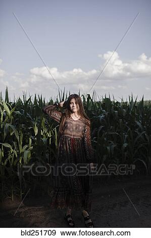 Stock Photo - Caucasian woman standing in cornfield. Fotosearch