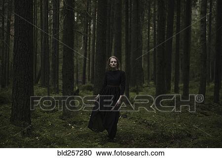 Caucasian woman standing in dark forest View Large Photo Image Stock Image - Caucasian woman standing in dark forest. Fotosearch
