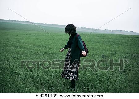 Stock Photo - Caucasian woman standing in field of grass. Fotosearch