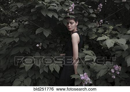 Stock Photograph - Caucasian woman standing in flowers. Fotosearch