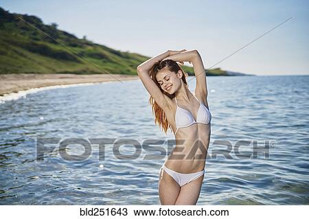 Stock Image - Caucasian woman standing in ocean. Fotosearch