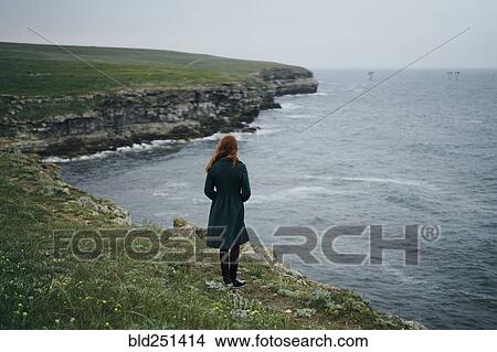 Picture - Caucasian woman standing near ocean. Fotosearch