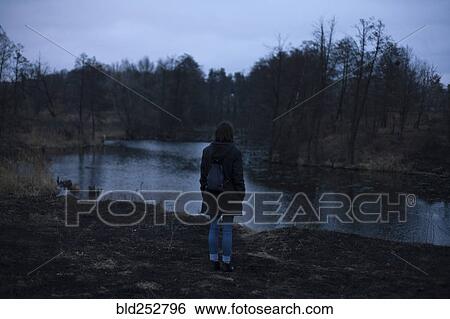Caucasian woman standing near river at night View Large Photo Image Stock Photograph - Caucasian woman standing near river at night. Fotosearch