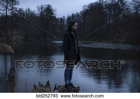 Stock Image - Caucasian woman standing near river. Fotosearch