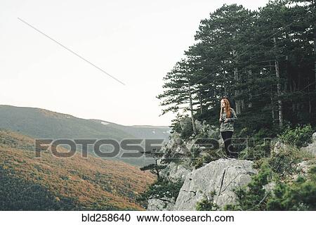 Caucasian woman standing on rock admiring scenic view of landscape View Large Photo Image Stock Image - Caucasian woman standing on rock admiring scenic view of landscape. Fotosearch