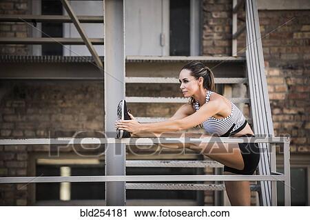 Caucasian woman stretching leg on urban staircase View Large Photo Image Stock Image - Caucasian woman stretching leg on urban staircase. Fotosearch