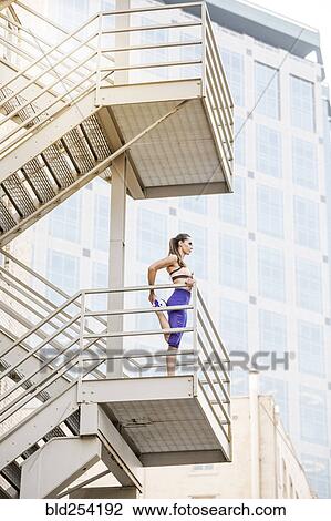 Caucasian woman stretching leg on urban staircase View Large Photo Image Stock Image - Caucasian woman stretching leg on urban staircase. Fotosearch