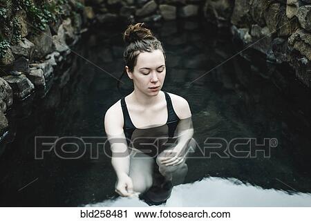 Stock Image - Caucasian woman swimming in pond. Fotosearch