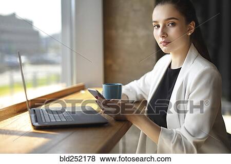 Caucasian woman texting on cell phone and drinking coffee View Large Photo Image Stock Photo - Caucasian woman texting on cell phone and drinking coffee. Fotosearch