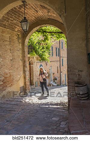 Stock Image - Caucasian woman under arch over sidewalk. Fotosearch