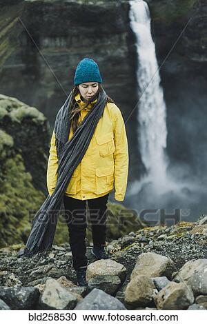 Stock Image - Caucasian woman walking near waterfall. Fotosearch