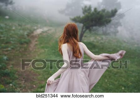 Picture - Caucasian woman wearing a dress in field. Fotosearch