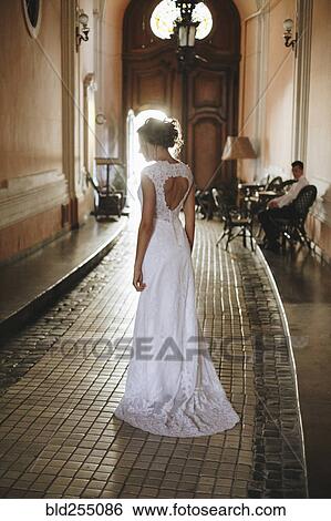 Stock Photograph - Caucasian woman wearing a wedding dress in hallway. Fotosearch