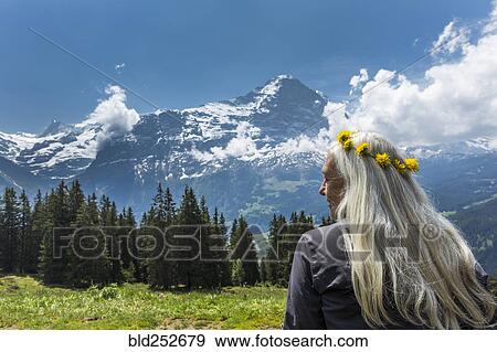 Stock Photo - Caucasian woman wearing crown of flowers near mountains. Fotosearch