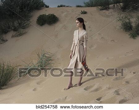 Caucasian woman wearing dress on beach carrying shoes View Large Photo Image Stock Photo - Caucasian woman wearing dress on beach carrying shoes. Fotosearch