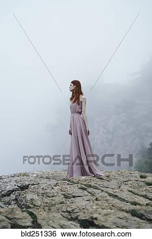 Caucasian woman wearing dress on rock in fog View Large Photo Image Stock Photograph - Caucasian woman wearing dress on rock in fog. Fotosearch