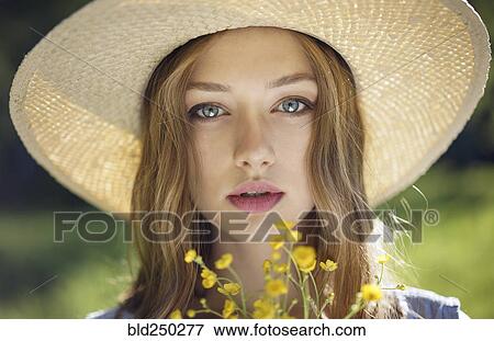 Caucasian woman wearing hat holding wildflowers View Large Photo Image Stock Photo - Caucasian woman wearing hat holding wildflowers. Fotosearch