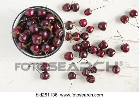 Stock Photograph - Cherries and bowl on white wooden table. Fotosearch