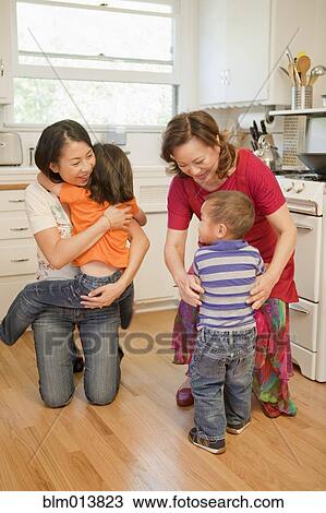 Stock Image - Chinese family bonding in kitchen. Fotosearch
