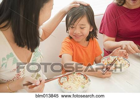 Stock Photography - Chinese family eating with chopsticks. Fotosearch