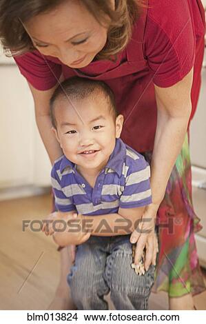 Picture - Chinese grandmother playing with grandson. Fotosearch